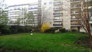 a grassy yard in front of a building at Appart T2 standing tout confort au calme - parking en option in Lyon