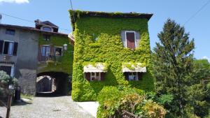 un bâtiment recouvert de lierre vert à côté d'un bâtiment dans l'établissement The House on the Bridge- La Casa sul Ponte, à Menaggio