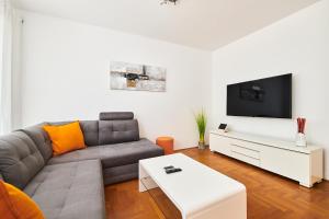 uma sala de estar com um sofá e uma televisão em Villa Perla em Umag