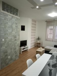 a white living room with a couch and a tv at GRAND Jagodina in Jagodina