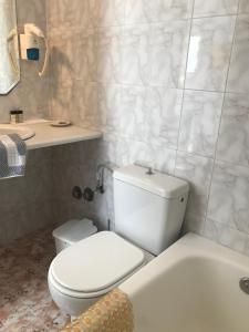a bathroom with a toilet and a sink and a tub at Romantika in Platis Gialos