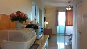 a kitchen with a vase of flowers on a counter at Santipran Place in Udon Thani +138 photos