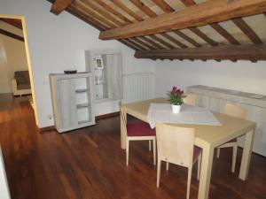 comedor con mesa, sillas y nevera en Teodora Apartment en Ravenna