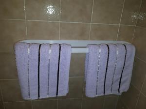 - 2 serviettes violettes suspendues à un porte-serviettes dans la salle de bains dans l'établissement Studio with balcony, à Jelsa