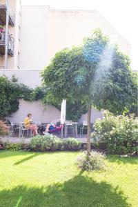 a man sitting in a chair under a tree at Hotel Stadthaus in Erlangen