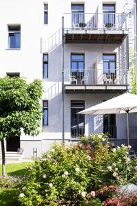 un edificio de apartamentos con sombrilla y algunos arbustos en Hotel Stadthaus, en Erlangen