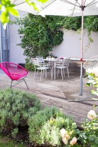 un patio con mesa, sillas y sombrilla en Hotel Stadthaus, en Erlangen