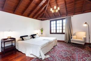 ラ・オロタバにあるPillowAbroad - La Casitaのベッドルーム(大型ベッド1台、椅子付)
