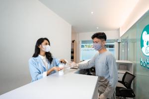 un homme et une femme dans une salle d'hôpital avec masques dans l'établissement Bobopod Paskal, Bandung, à Bandung