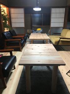 um quarto com sofás, mesas e cadeiras em ゲストハウス三軒家 em Shirahama