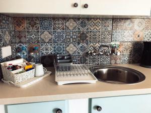 a kitchen counter with a sink and a dish rack at Katsikantaris Homes in Paphos +218 photos