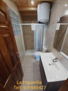 La salle de bains est pourvue d'un lavabo blanc et de toilettes. dans l'établissement Alojamientos Rurales La Higuerilla Sierra de Cazorla, à Burunchel