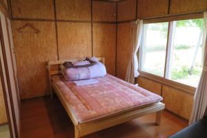 斜里町Mizu no Gakko的一间卧室，配有一张床、枕头和一扇窗户
