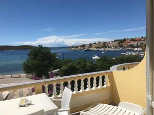 einen Balkon mit einem Tisch und Stühlen sowie Blick auf das Wasser in der Unterkunft Apartments and Rooms Villa Luci in Barbat na Rabu