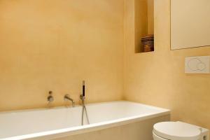 a bathroom with a bath tub and a toilet at The Little Townhouse in Amsterdam