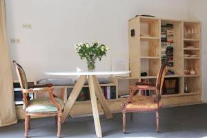 uma mesa com duas cadeiras e uma mesa com um vaso em The Little Townhouse em Amsterdã