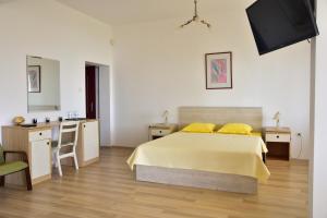 a bedroom with a bed and a desk and a television at Guest Rooms Sea View in Balchik