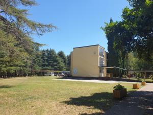 a building in a park with a yard at Youth Hostel Pinesta in Novigrad Istria