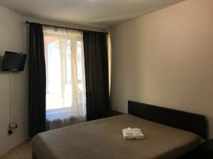 a bedroom with a bed with two towels on it at Apartament Sunny, Варна- център in Varna City