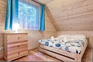 a bedroom with a bed in a wooden cabin at Domki Skiba Szaflary in Szaflary