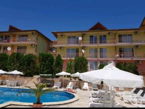 a hotel with a pool and chairs and an umbrella at Курортно студио in Sunny Beach