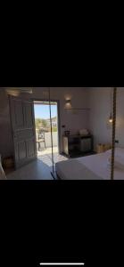 a bedroom with a door open to a patio at Blue Sky in Ios Chora