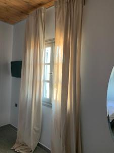 a curtain in a room with a window at Blue Sky in Ios Chora