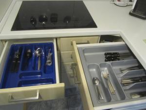 a kitchen with an open cabinet with utensils at Apartment für zwei in Neukirchen vorm Wald