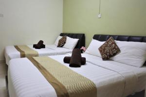 2 letti posti uno accanto all'altro in una stanza di Camlodge Budget Hotel a Cameron Highlands