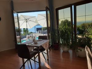 a dining room with a table with chairs and an umbrella at B&B Eva in Ičići