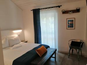 a bedroom with a bed and a chair and a window at Casello68 in Levanto