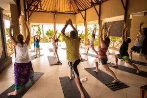 a group of people doing yoga in a room at Puri Dajuma Beach Eco-Resort & Spa in Pulukan