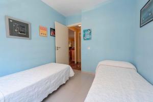 two beds in a room with blue walls at Apartamentos Nuevo México C 432 in Calpe