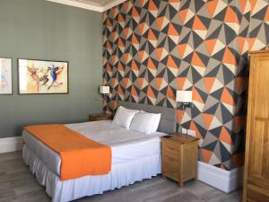 a bedroom with a bed and a geometric wall at Da Vinci Eastbourne in Eastbourne