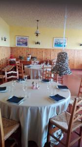 une salle à manger avec des tables et des chaises blanches et un lustre dans l'établissement Alla Torre Antica, à Ruttàrs