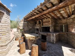 an outdoor kitchen in a stone building with wooden beams at Agriturismo Sole Luna in Piano Delle Pieve