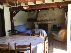 sala de estar con mesa y chimenea en Maison Coeur de Brenne en Rosnay