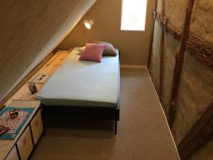 Dormitorio con cama con almohada rosa en Zum Schwalbennest, en Wredenhagen