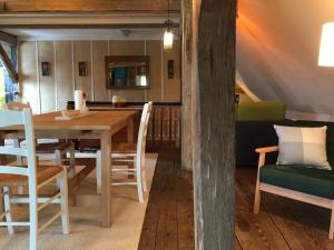 una sala da pranzo con tavolo e sedie in legno di Zum Schwalbennest a Wredenhagen