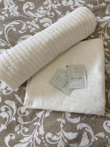 a roll of white towels sitting on a bed at SATYS Apartments in Ostrava
