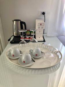 bandeja con tazas de té y platillos en una mesa en Sunrise Rooms en Grado