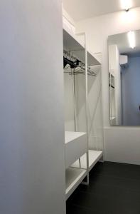 a bathroom with white shelves and a mirror at Sunrise Rooms in Grado +24 photos
