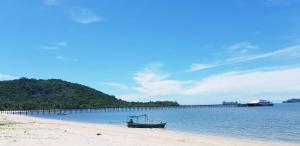 a boat sitting on the beach next to a pier at Magic House - No Pets Allowed in Chumphon