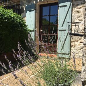 una puerta abierta de una casa con flores púrpuras en Lavande- Gasquerie gites en Puisseguin