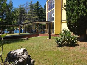 ein großes Gebäude mit einem Garten davor in der Unterkunft Youth Hostel Pinesta in Novigrad Istria