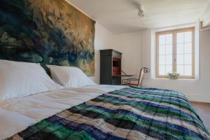 ein Schlafzimmer mit einem großen Bett und einem Gemälde an der Wand in der Unterkunft Amitié in Kinrooi