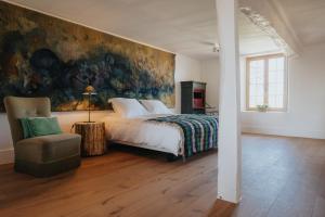 a bedroom with a bed and a painting on the wall at Amitié in Kinrooi