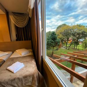 Una habitación con dos camas y una gran ventana. en Pousada Vovô Nino, en Gramado