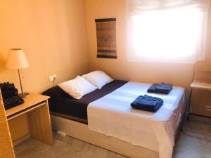 a bedroom with a bed with two bags on it at Junto a FIBES, amplio, luminoso, con piscina y parking in Seville