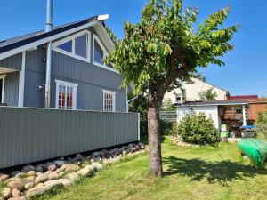 a house with a tree in the yard at Haffblick in Altwarp